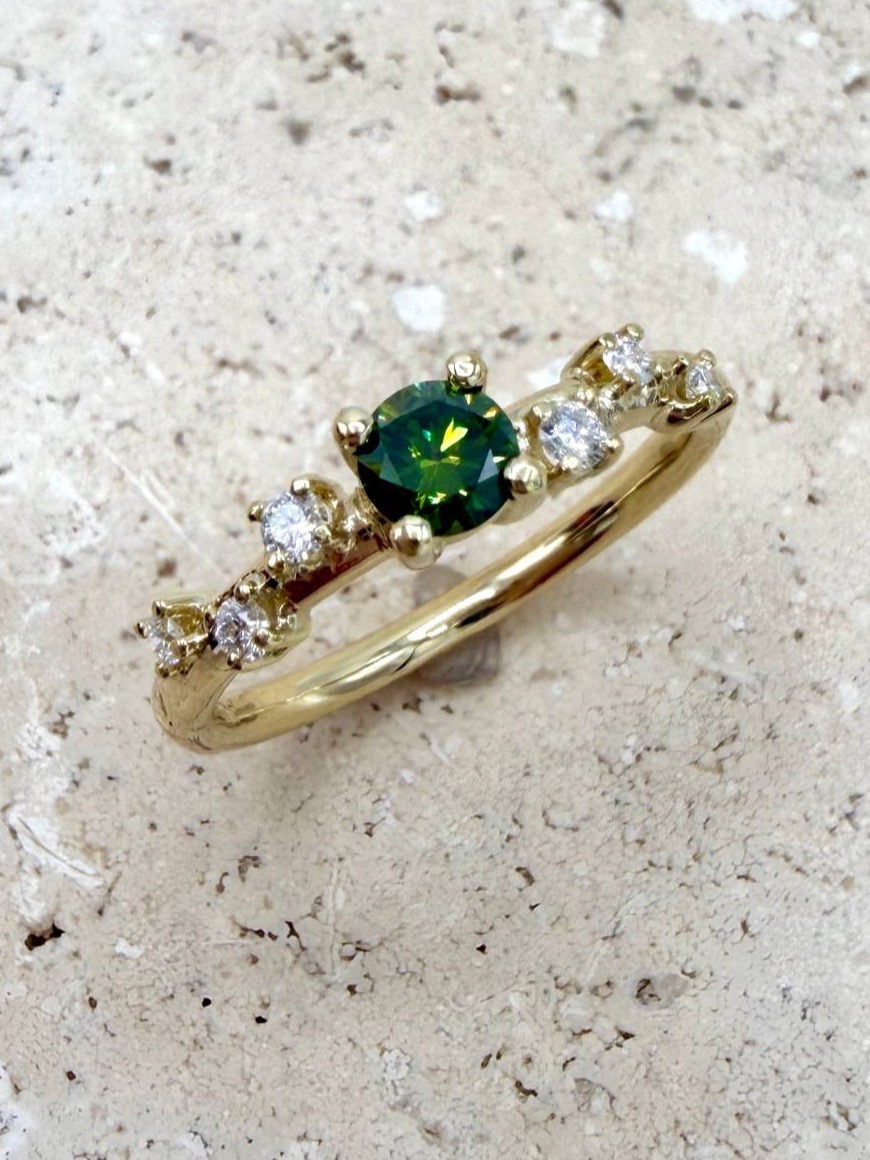 Ring aus 750er Gelbgold mit grünem Edelstein und weißen Steinen