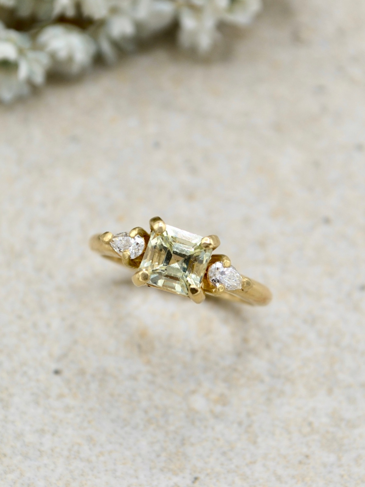 Ring mit hellgrünem Edelstein und tropfenförmigen Diamanten