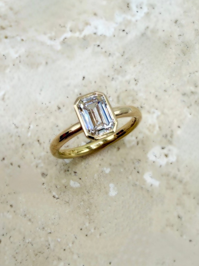 Solitärring aus 750er Gelbgold mit Stein im Smaragdschliff in Zargenfassung